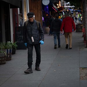 Man with Blue Gloves walking down the street