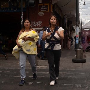 Two women with baby walking down the street in Publa City