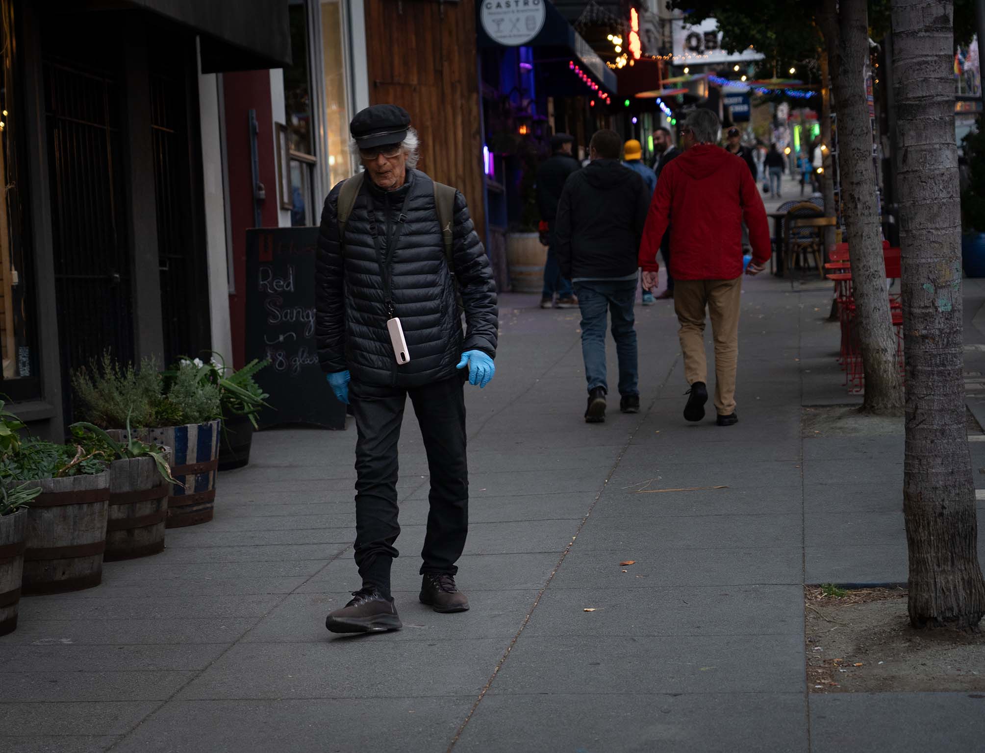 Man with Blue Gloves walking down the street