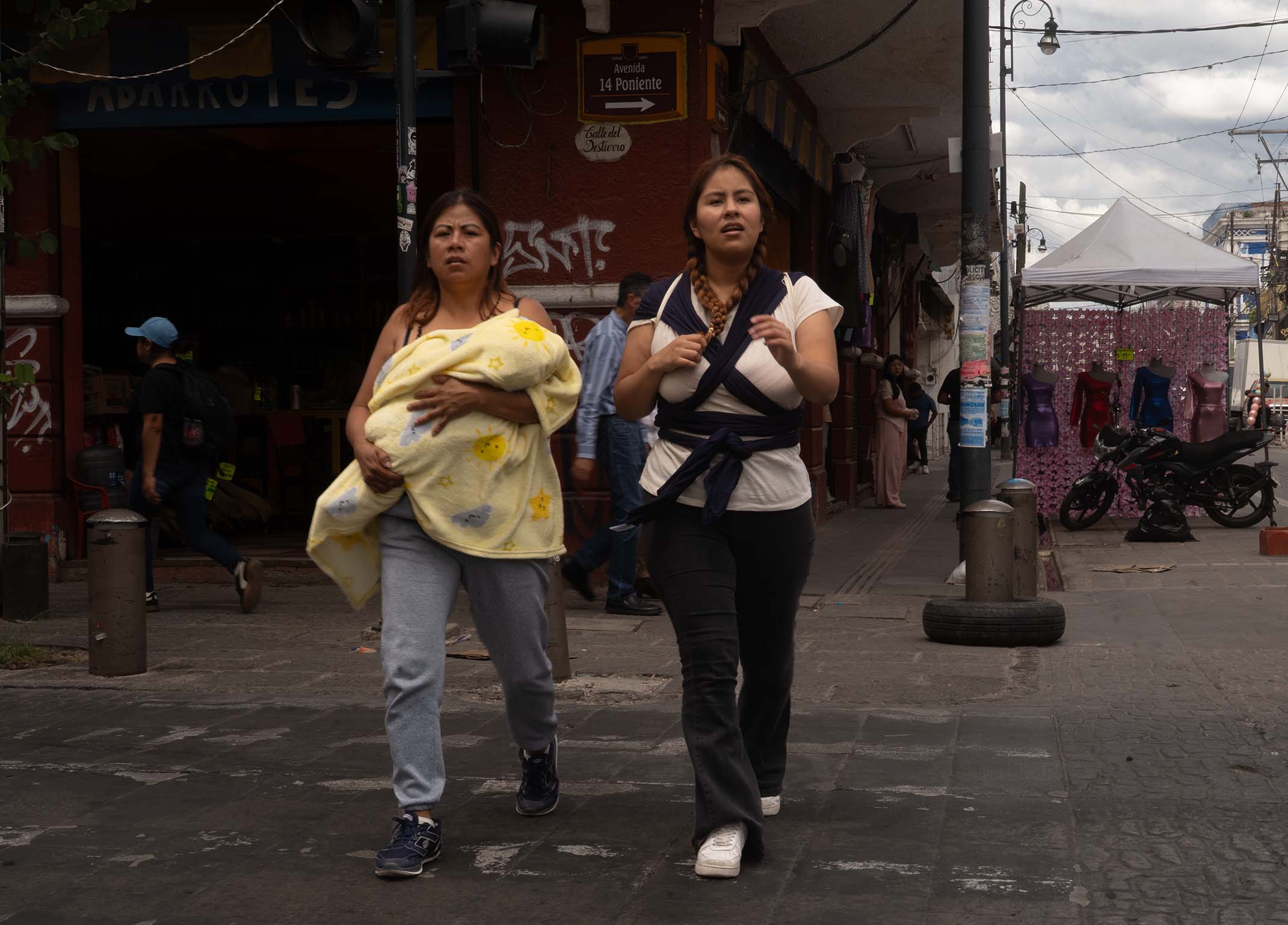 Two women with baby walking down the street in Publa City